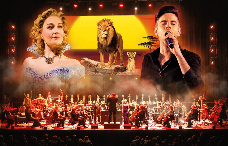 Ein Orchester auf einer Bühne; im Hintergrund ist eine Szene aus "Der König der Löwen" sowie eine Sängerin und ein Sänger zu sehen